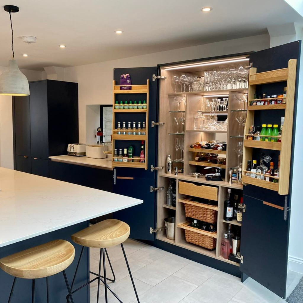 Navy fitted kitchen with hidden drinks cabinet, integrated storage and island seating
