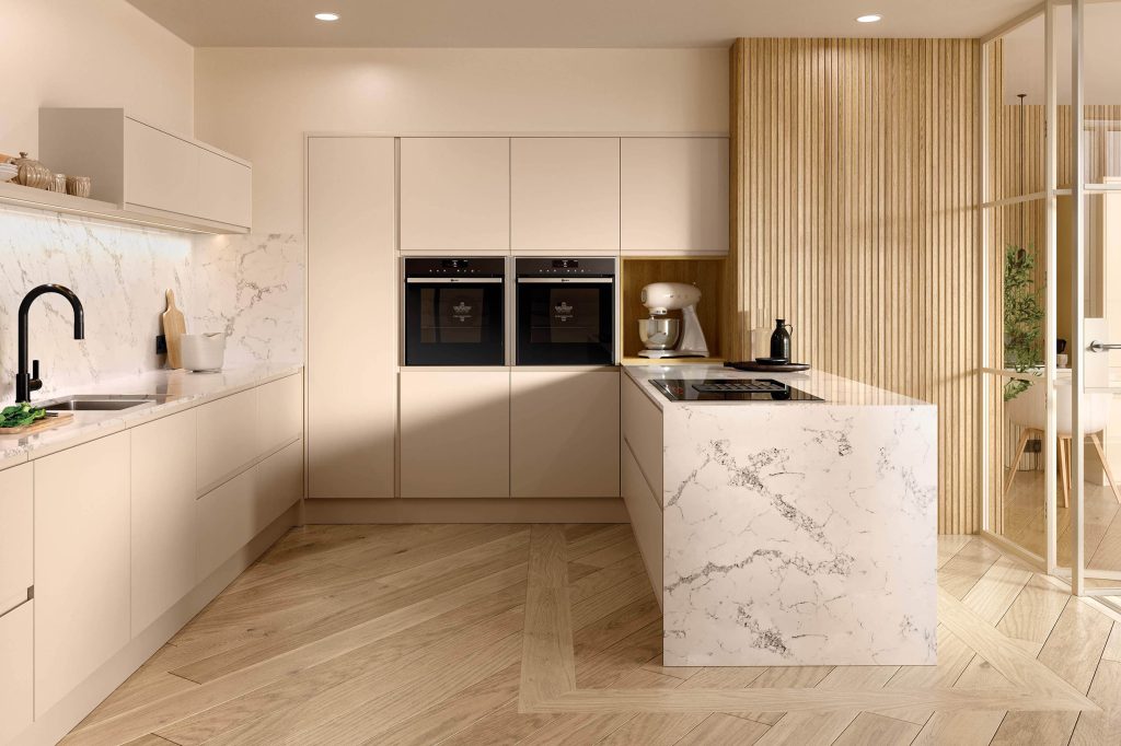 Cream handleless kitchen with marble waterfall island, double ovens and oak herringbone flooring